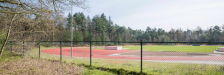 Atletiekbaan achter een hek van sportpark Dijnselburg
