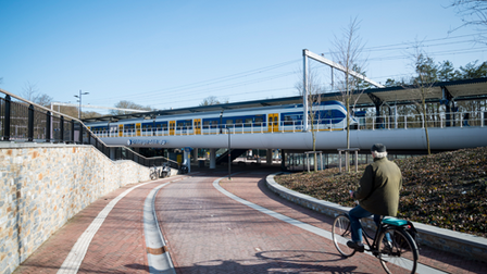 Fietser fietst op het fietspad richting fietserstunnel onder station Driebergen Zeist